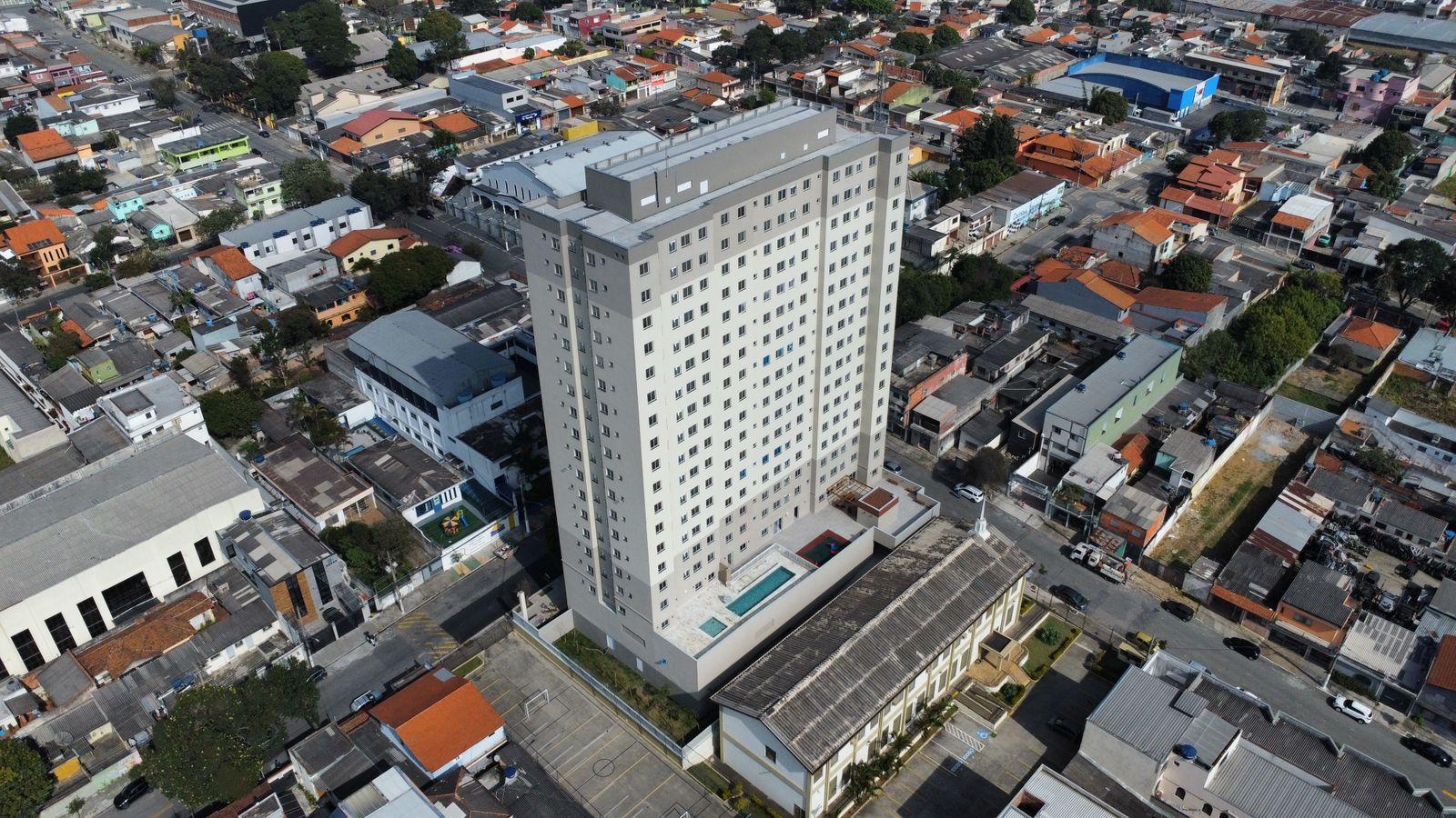 Vista aérea do Livus Barena, torre residencial entregue entre as casas do bairro em São Paulo.